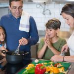 A happy family collaborates on a meal preparation in a stylish kitchen.